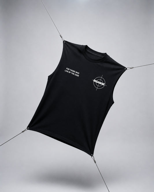 A black sleeveless crop top with white printed graphics, suspended by thin wires against a light gray studio background.