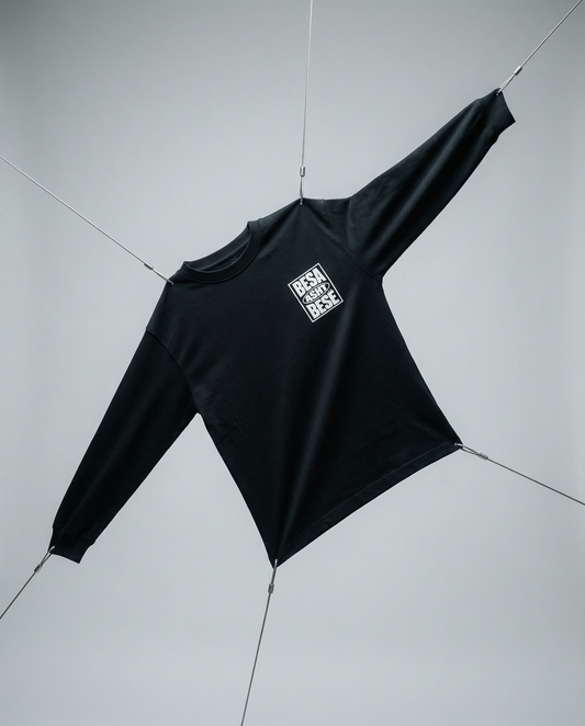 Black long-sleeve shirt with a logo on a light gray background