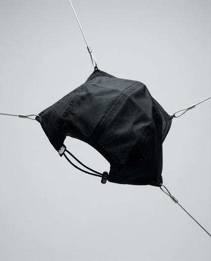 Black bag hanging from a wire against a light gray background