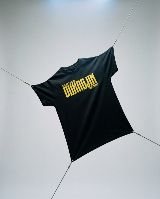 Black t-shirt with yellow text on a light gray background