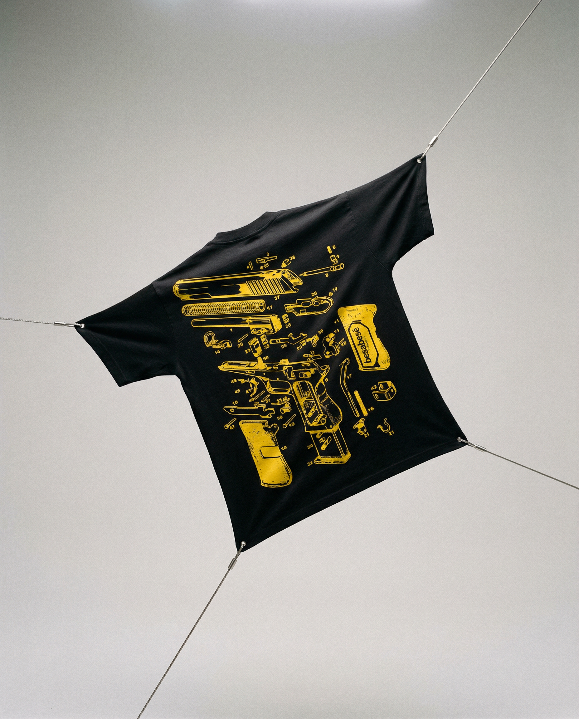 Black t-shirt with yellow graphic design on a white floor