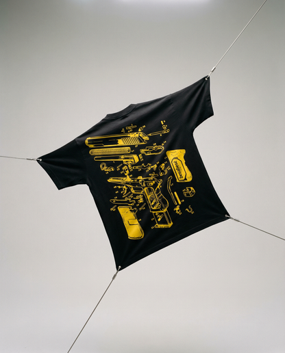 Black t-shirt with yellow graphic design on a white floor