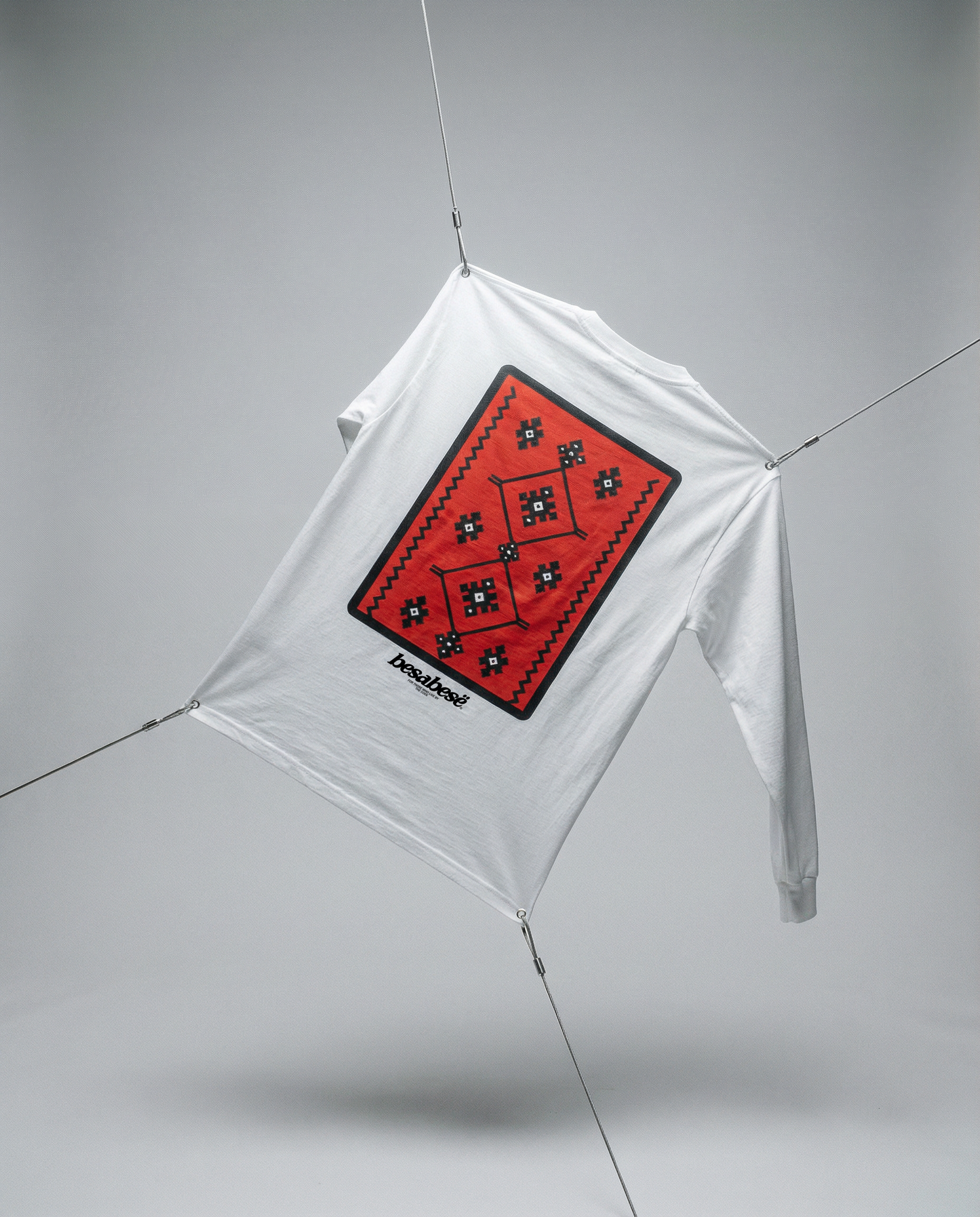 White kite with a red diamond-shaped design on a gray background