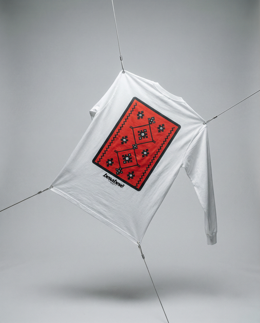 White kite with a red diamond-shaped design on a gray background