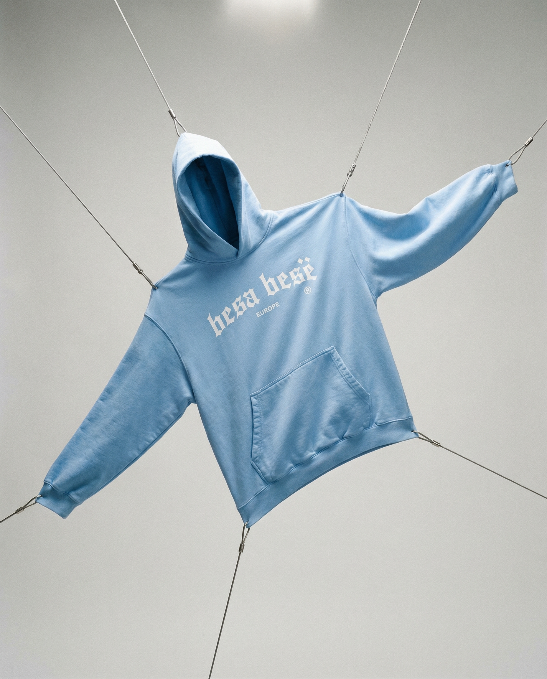 Light blue hoodie with 'herschel' branding on a gray background