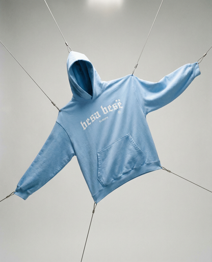 Light blue hoodie with 'herschel' branding on a gray background
