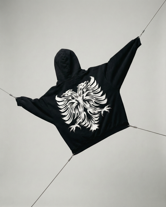 Black hoodie with a white eagle design on a light gray floor.