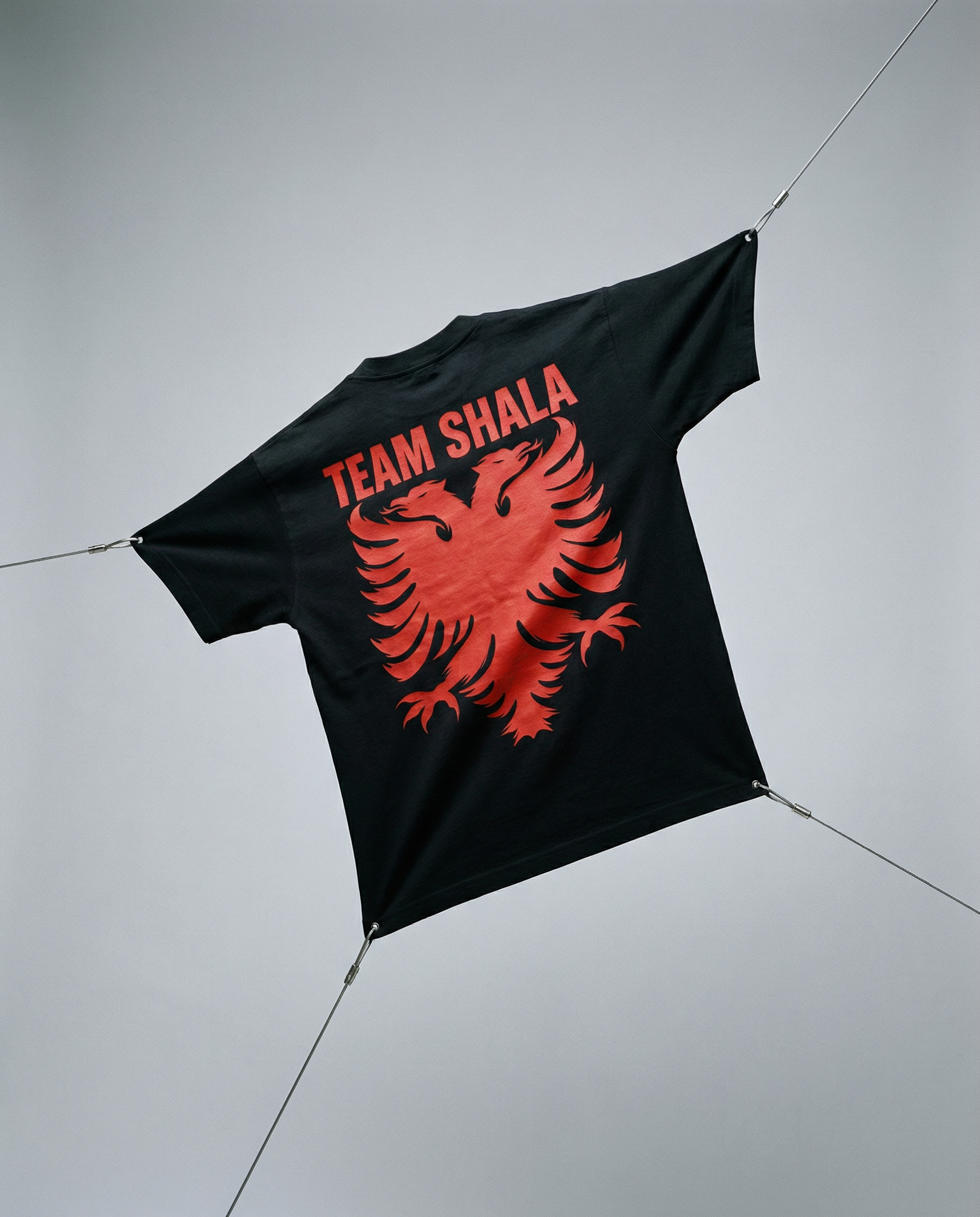 Black t-shirt with red eagle design and 'Team Shala' text on a light gray background